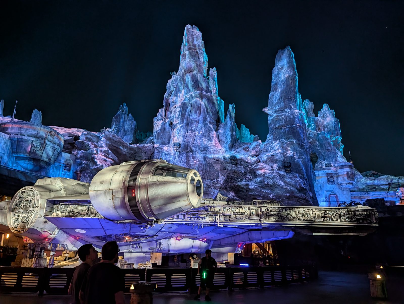 The Millennium Falcon in front of rocky spires at night at Galaxy's Edge